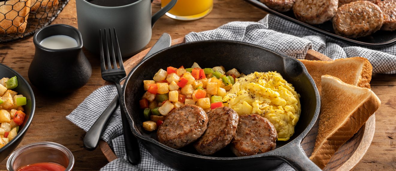 Pork Sausage breakfast patties in skillet with eggs and veggies