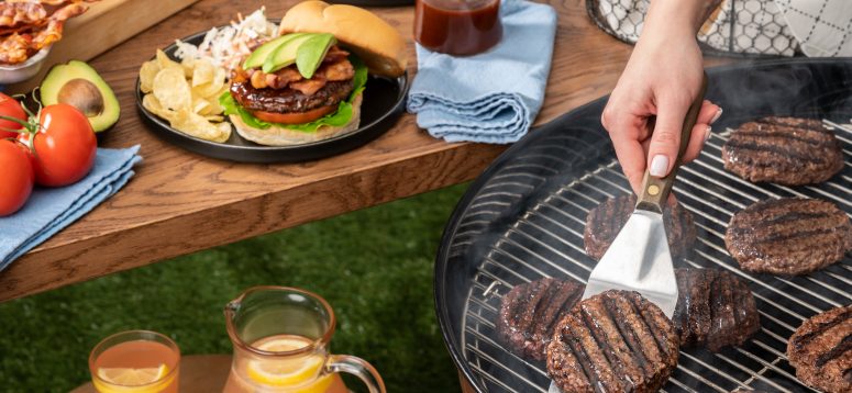 Grilling burgers and picnic table set for a bbq