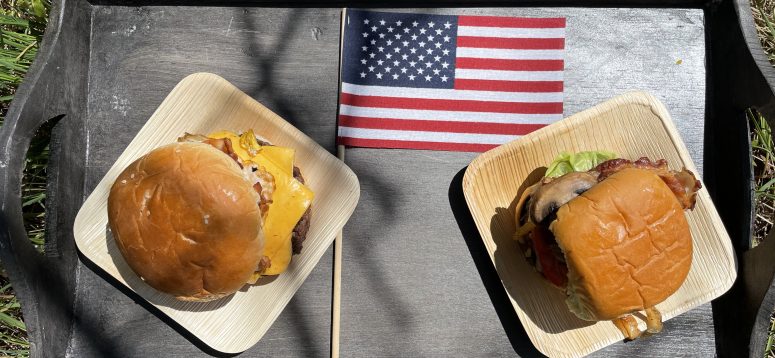 two burgers on tray with an american flag.